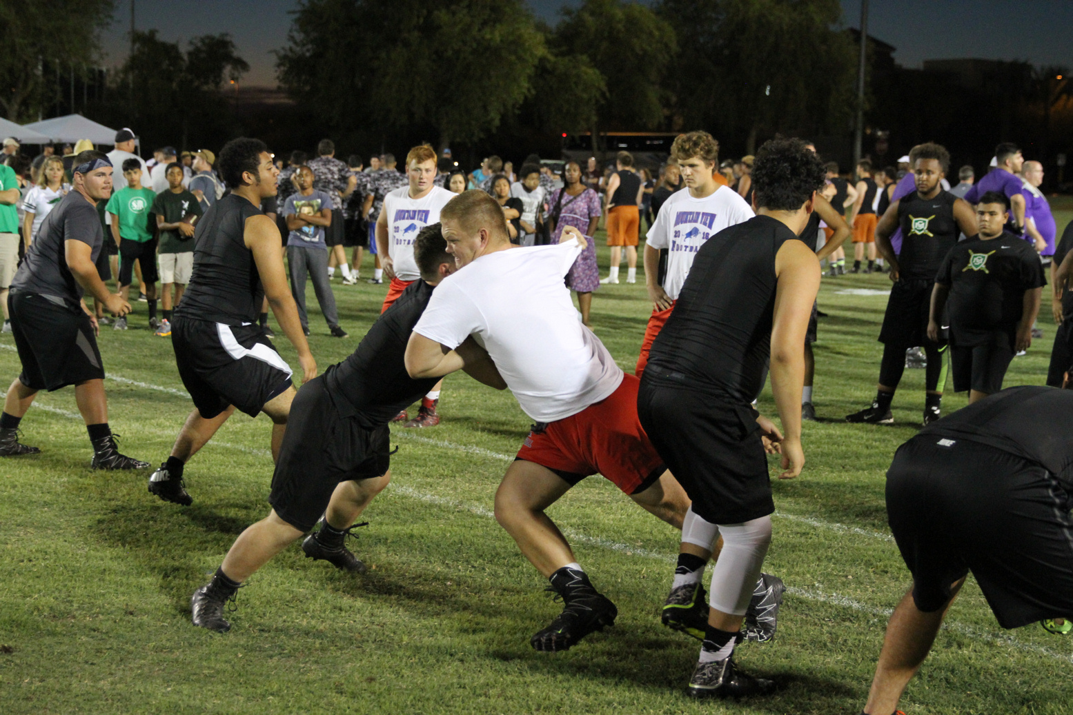 Group of football players tackling each other